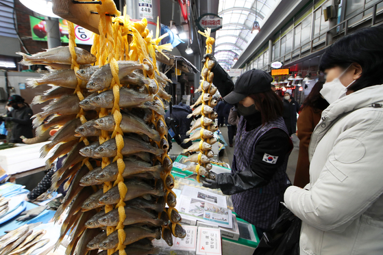 People purchase gulbi, or dried yellow corvina, from Malbawoo Market in Gwangju ahead of the Lunar New Year holidays which start Saturday. [YONHAP]