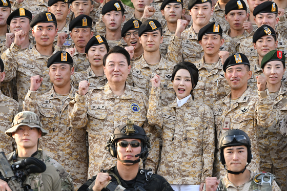 President Yoon Suk Yeol, center left, and first lady Kim Keon-hee, center right, pose for a commemorative photo with the South Korean Army’s Akh unit during a state visit to the United Arab Emirates on Sunday. [JOINT PRESS CORPS]