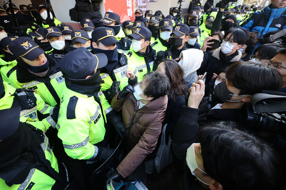 Police and members of the Korean Confederation of Trade Unions face off as investigators from the National Intelligence Service and National Police Agency raid the group's headquarters in Jung District, central Seoul Wednesday morning. [YONHAP]
