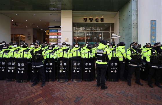 Police officers block the entrace of the Korean Confederation of Trade Unions' Seoul office while the National Intelligence Service raids the building in Jung District, central Seoul, on Wednesday morning. [YONHAP]