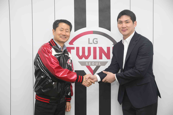 Oh Ji-hwan, right, shakes hands with LG Sports CEO Kim In-seok after signing a six-year deal worth 12.4 billion won with the LG Twins on Jan. 19. [YONHAP] 