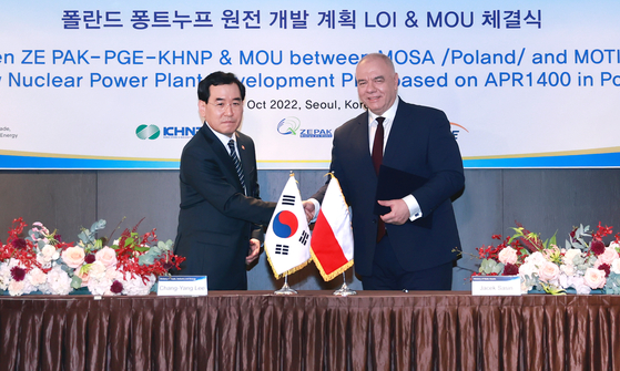 Industry Minister Lee Chang-yang, left, and Poland's Deputy Prime Minister and Minister of State Assets Jacek Sasin shake hands last October after signing a letter of intent to cooperate on the development of a nuclear power plant in Poland. 