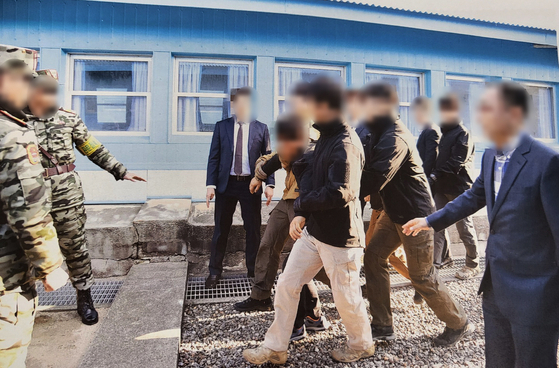. In a photograph released by the Unification Ministry in July, one of the two North Korean fishermen to be repatriated via Panmunjom on Nov. 7, 2019 drags his feet as he is forced to return to the North. [NEWS1]