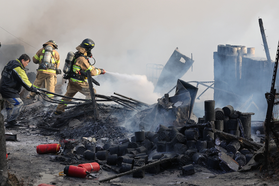 Firefighters battle a fire that broke out in Guryong village in southern Seoul, on Friday morning. [YONHAP]