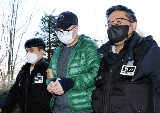 A 27-year old American, who is accused of breaking into subway garages and spray painting graffiti on trains last year, being escorted into Incheon District Court on Friday. [YONHAP]