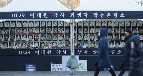 People pass by the joint memorial altar of crowd crush victims, set up by a civic group formed by the bereaved family and located at Noksapyeong Station, on Jan. 3. [NEWS1] 