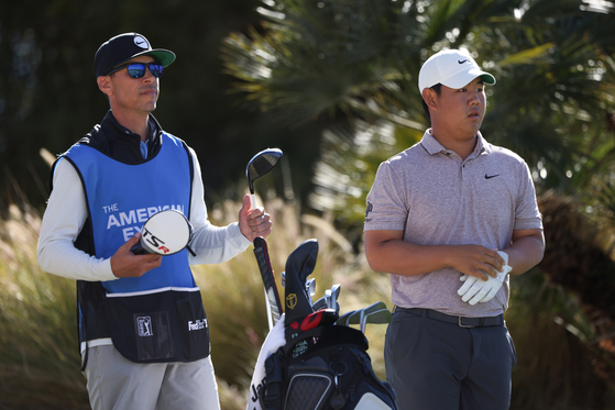 Kim Joo-hyung, right, and caddie Joe Skovron look on from the 18th tee during the second round of The American Express at PGA West Nicklaus Tournament Course on Friday in La Quinta, California.  [GETTY IMAGES]