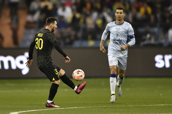 Lionel Messi of PSG in action against Cristiano Ronaldo of Riyadh XI during during an exhibition match at the King Fahd Stadium in Riyadh on Friday.  [EPA/YONHAP]