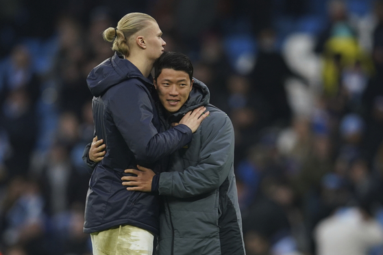 Manchester City's Erling Haaland, left, hugs Wolverhampton Wanderers' Hwang Hee-chan after a Premier League match at the Etihad Stadium in Manchester on Sunday.  [AP/YONHAP]