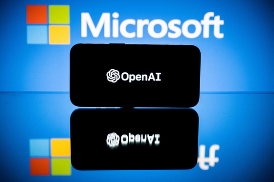 Screens display the logos of Microsoft and OpenAI. Microsoft extended on January 23 its partnership with with OpenAI, the research lab and creator of ChatGPT, in a ″multiyear, multibillion dollar investment″ [AFP] 