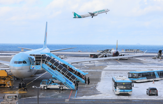 Passengers are getting on flights at Jeju International Airport on Wednesday morning after all flights were canceled the day earlier due to strong winds and heavy snow. [YONHAP] 