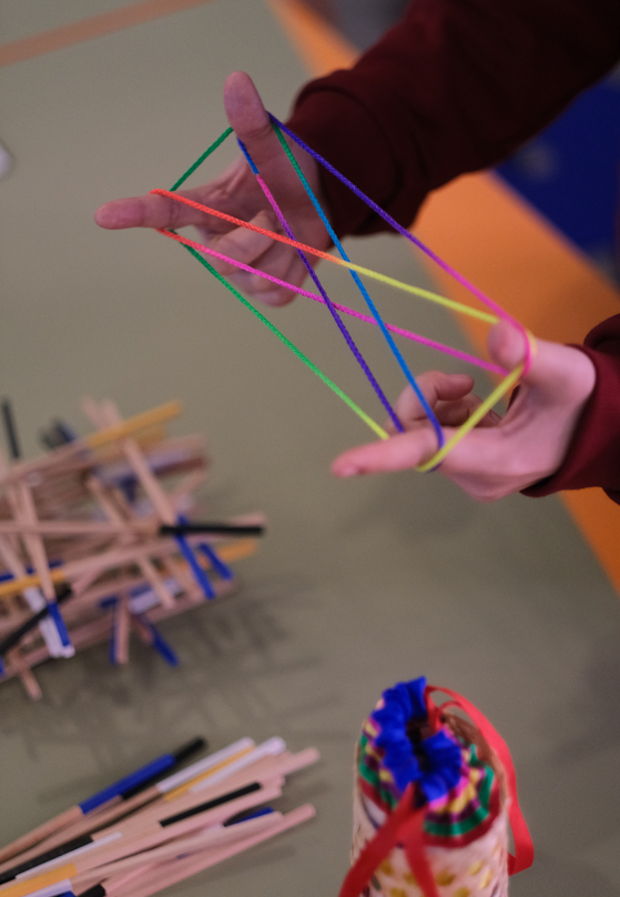 Visitors are able to play Korean traditional children's games at the "Newtro Festival" in Culture Station Seoul 284 in Jung District, central Seoul, like cat's cradle, shown here. [YONHAP]