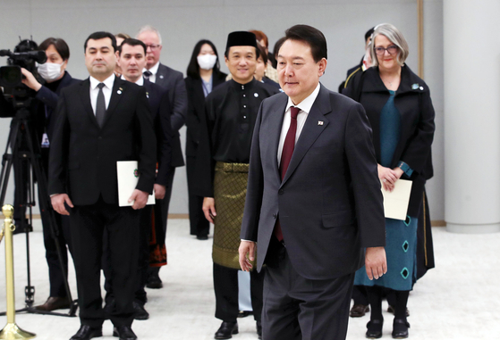 President Yoon Suk Yeol enters a room at the president’s office in Yongsan District, central Seoul, on Thursday where ambassadors from 12 countries wait to present their credentials to the Korean president. The 12 countries are Ireland, Kuwait, Malaysia, Uruguay, Turkmenistan, Norway, Hungary, Nepal, Azerbaijan, Turkey, India and Ecuador. [JOINT PRESS CORPS]