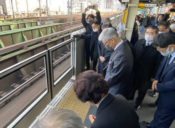 Korea's ambassador to Japan Yoon Duk-min, Lee Soo-hyun's mother and other mourners pay silent tribute Thursday at a subway platform at Shinokubo Station in Tokyo, where Lee Soo-hyun died at the age of 26 after trying to save a drunken Japanese man in January 2001. Thursday marks 22 years since the tragedy occurred. [YONHAP] 