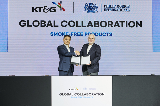 KT&G CEO Baek Bok-in, left, and PMI CEO Jacek Olczak sign a 15-year supply deal to globally distribute KT&G's smoke-free products at a commemorative ceremony at the Conrad Hotel in Yeouido, western Seoul, on Monday. [KT&G]