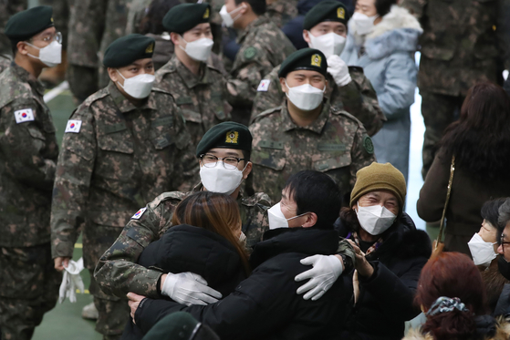 An Army private hugs his relatives after completing basic military training in Daegu, southern Korea, on Jan. 25. [NEWS1]