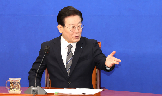 Democratic Party chairman Lee Jae-myung answers questions by reporters at his office at the National Assembly on Monday. [YONHAP]