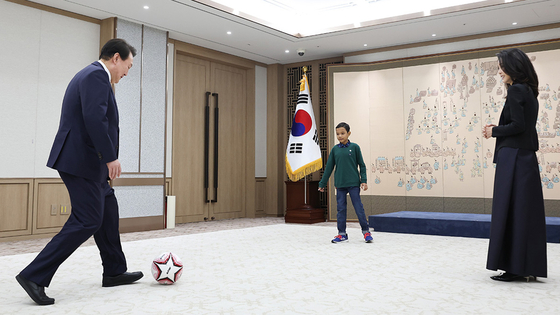 President Yoon Suk Yeol, left, and first lady Kim Keon-hee play ball with a 14-year-old Cambodian child after gifting the soccer ball to the child at the presidential office in Yongsan District, central Seoul on Tuesday. Yoon and Kim visited the child's home during a trip to Cambodia last November to encourage him after he received heart surgery at Hebron Medical Center in Phnom Penh. The child, who suffered from heart disease, came to Korea for follow-up surgery last month. [YONHAP]