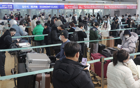 Travelers off to Shanghai stand in line to check in for their flights at Incheon International Airport on Wednesday. [YONHAP] 