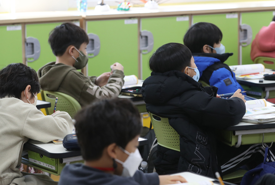 Students wear masks during class in a school in Ulsan, southern Korea, on Monday. Korea lifted its indoor mask mandate Monday except at hospitals, pharmacies, and on public transportations. [YONHAP]