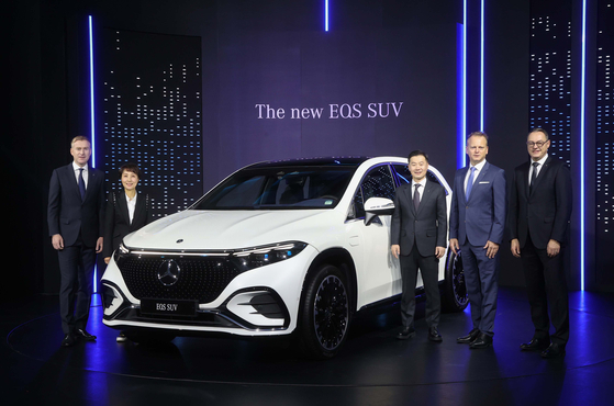 Officials from Mercedes-Benz Korea including Vice Presidents Johannes Schoen, far left, and Lee Sang-kuk, third from left, take a photo with the EQS SUV at a press conference on Wednesday. [MERCEDES-BENZ KOREA] 