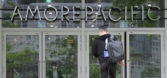 An employee enters Amorepacific Group’s headquarters in Yongsan District, central Seoul. [ YONHAP ]