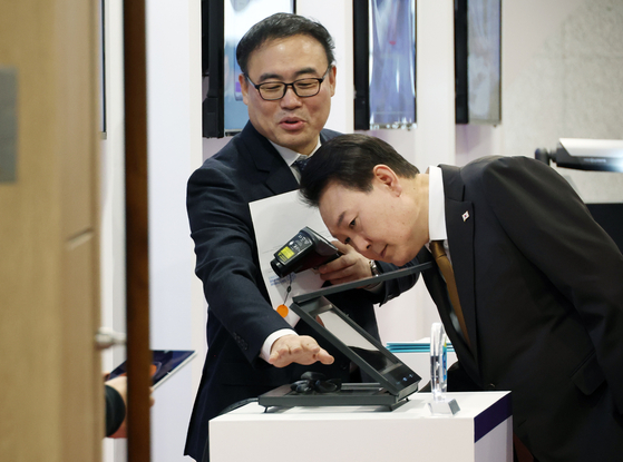 President Yoon Suk Yeol being briefed on a virtual fire place developed by Graphene Square, a start-up that received an innovation award at the CES last month, at the president’s office in Yongsan, Seoul, on Thursday. [YONHAP]