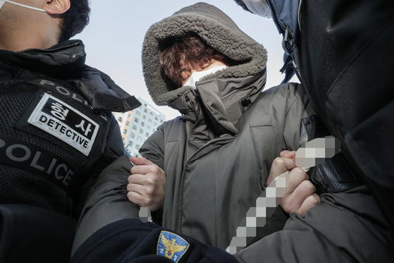 Lee Ki-young, suspected of killing a taxi driver and his former girlfriend, completely hides his face under a hood and face make as he leaves a police station in Goyang, Gyeonggi, for handover to the prosecution on Jan. 4. [YONHAP]
