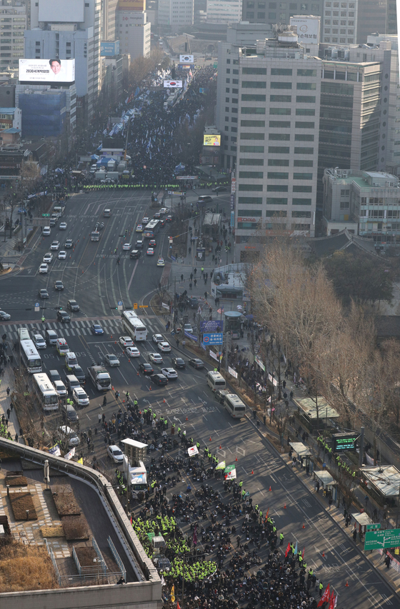 A memorial ceremony for victims of the Itaewon crowd surge, bottom, is held in downtown Seoul on Saturday near an antigovernment rally led by the Democratic Party. [YONHAP]