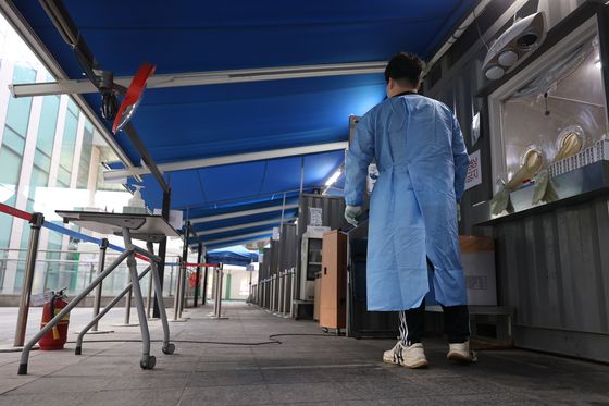 A medical staff at a Covid-19 testing center in Yongsan District, central Seoul, waits for patients on Friday morning. [YONHAP]