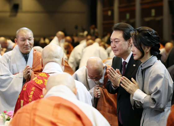 President Yoon Suk Yeol and first lady Kim Keon-hee greeted by Buddhist monks at a Buddhist New Year event held at COEX, southern Seoul, on Monday. This is the first time that a sitting president and the first lady have attended the Buddhist New Year mass. Some 30 different sects attended. [YONHAP] . 
