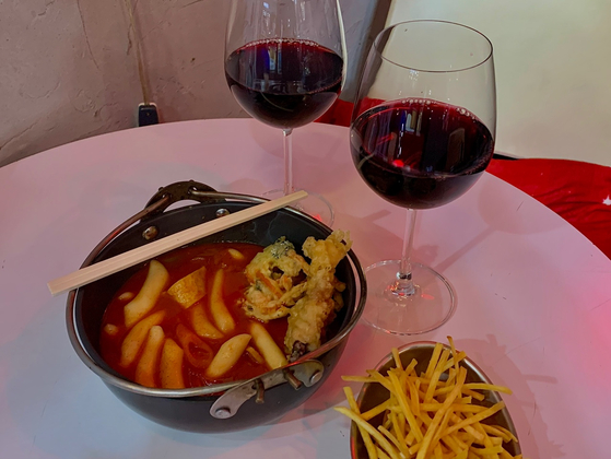 People can enjoy Jungang Market's street food with wine at SulSul 317, a bar inside the market in Jongno District, central Seoul. This photo shows tteokbokki (spicy rice cakes) and wine. [LEE JIAN]