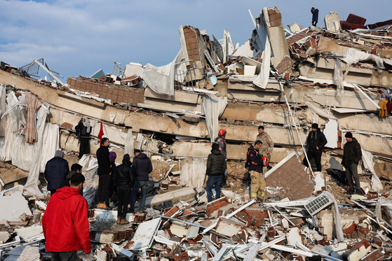 Rescue workers search for survivors in the rubble on Tuesday in Hatay, Turkey, after a powerful quake rocked southeast Turkey and Syria killing thousands of people. [REUTERS/YONHAP] 