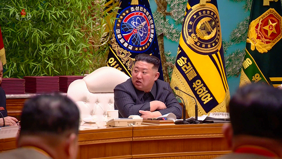 North Korean leader Kim Jong-un presides over a meeting of the ruling Workers' Party's Central Military Commission in footage released by the Korean Central Television (KCTV) on Tuesday. Visible behind Kim is the flag for a "Missile Management Agency," with a logo featuring a stylized version of the Hwasong-17 intercontinental ballistic missile. [YONHAP]