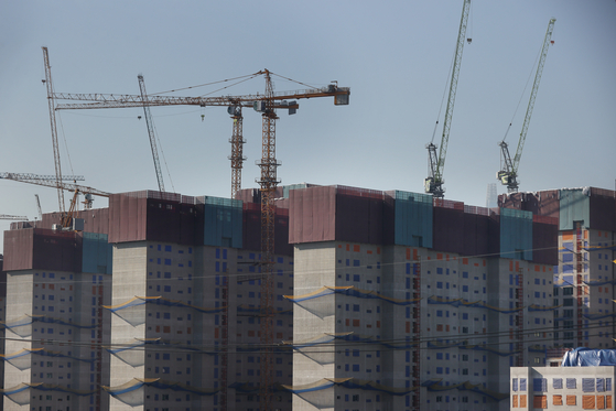 Housing units up for sale sit vacant as sales demand plummets, sending a red alert to related industries nationwide, such as in construction, maintenance and local government outside of Seoul. A photo above shows apartment complexes in Seoul under construction. [YONHAP]