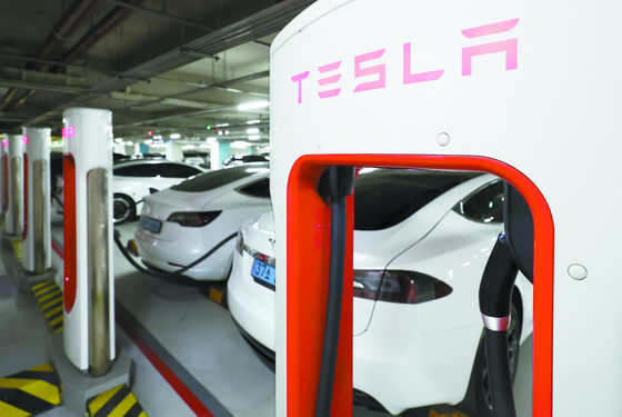 Tesla vehicles are being charged at a building in Seoul on Jan. 3. [YONHAP]
