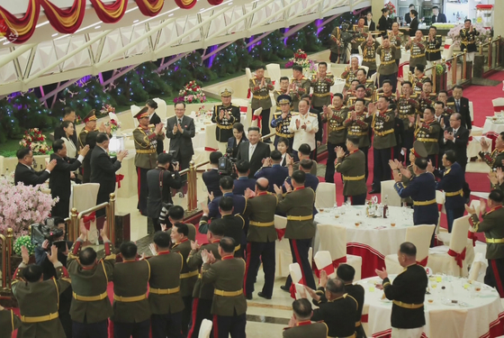 North Korean leader Kim Jong-un, his wife Ri Sol-ju and daughter Kim Ju-ae are applauded by military officers at a banquet in Pyongyang in photos released by state media on Wednesday. Kim's sister Kim Yo-jong, dressed in white, is visible at the far left side of the photo. [YONHAP]