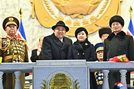 North Korean leader Kim Jong-un, left, observes Wednesday evening's military parade in downtown Pyongyang with his daughter Kim Ju-ae, right, in this photo released by the Korean Central News Agency (KCNA). [YONHAP]