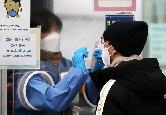 A medical staff at a Covid-19 testing center in Songpa District, southern Seoul, takes sample from a citizen on Feb. 2. [NEWS1]