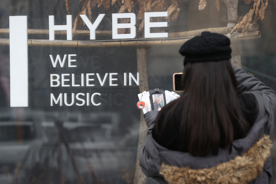 A passerby stops in front of HYBE headquarters on Friday in Yongsan, central Seoul. [YONHAP]