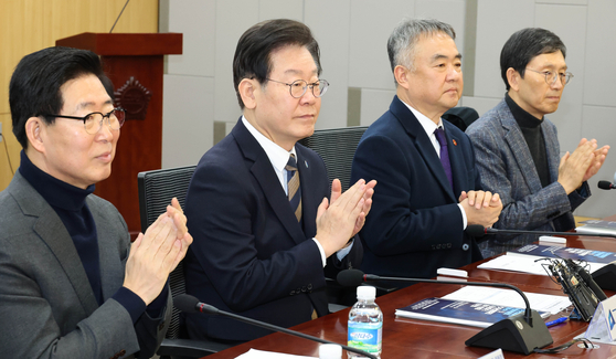 Democratic Party Chair Lee Jae-myung, second from right, attends a meeting at the National Assembly on Thursday. [YONHAP]