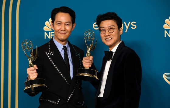 Actor Lee Jung-jae, left, and direcor Hwang Dong-hyuk, right, hold up their Emmys during the 74th Primetime Emmys at Microsoft Theater on September 12, 2022 in Los Angeles, California. [AFP]