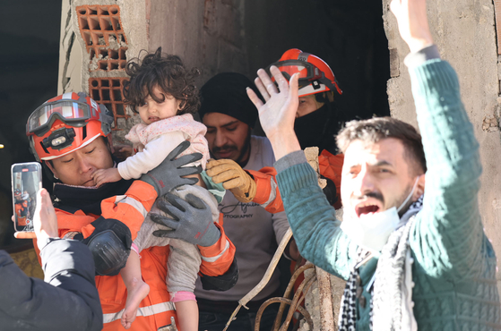 Members of the Korea Disaster Relief Team (KDRT) rescue a child who had been trapped inside a collapsed building in Antakya, Hatay, Thursday after a massive earthquake in Turkey earlier this week. [FOREIGN MINISTRY]