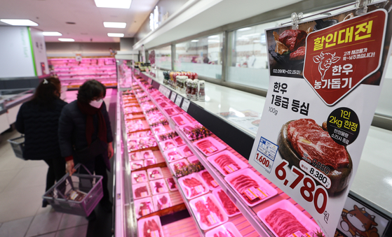 Customers stand in front of hanwoo, or Korean beef, displays at Hanaro Mart in Yongsan, Seoul, on Sunday. The Ministry of Agriculture, Food and Rural Affairs and Nonghyup announced a sales promotion on Sunday, selling hanwoo products at prices 20 percent lower than the nationwide average throughout the year. [YONHAP]