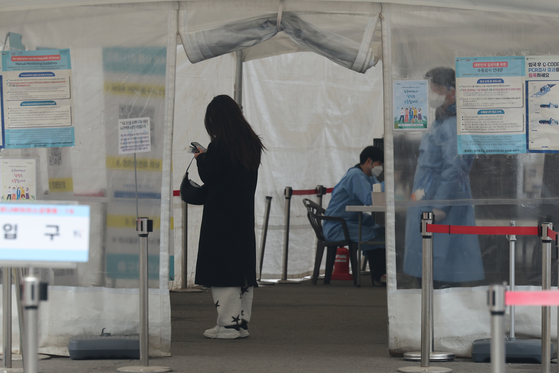 A citizen waits to take a Covid-19 test at a testing center in Seoul Station on Sunday. [YONHAP]