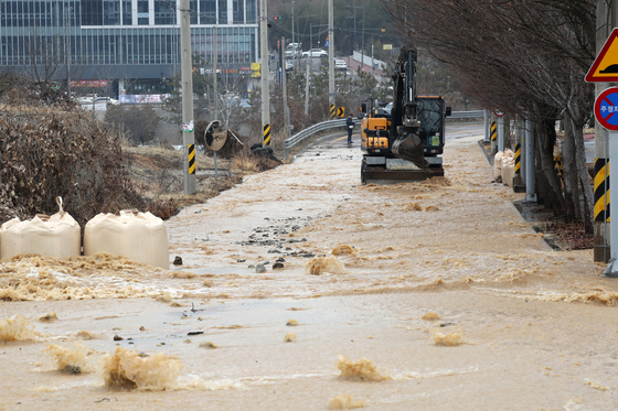 Tap water overflows into roads in the southwestern city of Gwangju on Sunday due to a valve malfunction at a water purification plant. [YONHAP]