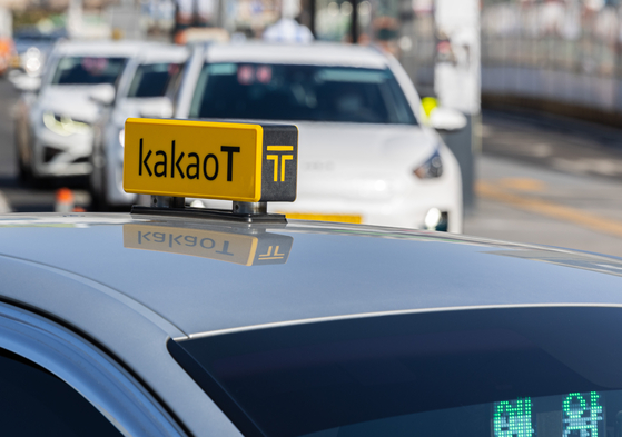 A Kakao T Blue taxi, booked with a call, waits for its passenger at a taxi lane in Seoul Station on Tuesday afternoon. [YONHAP]