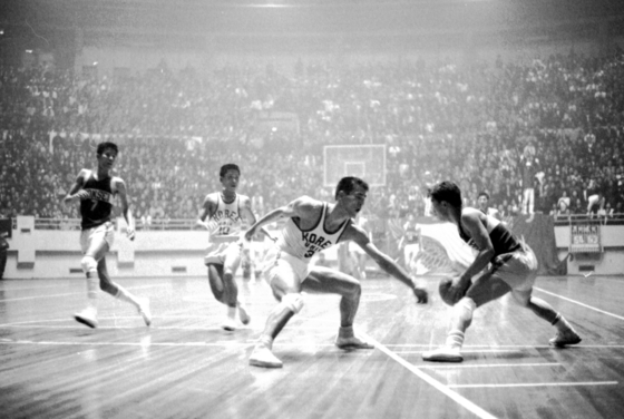 Students from Korea University and Yonsei University play basketball during a derby match at Jangchung Arena in Jung District of central Seoul in 1965. [JOONGANG ILBO] 