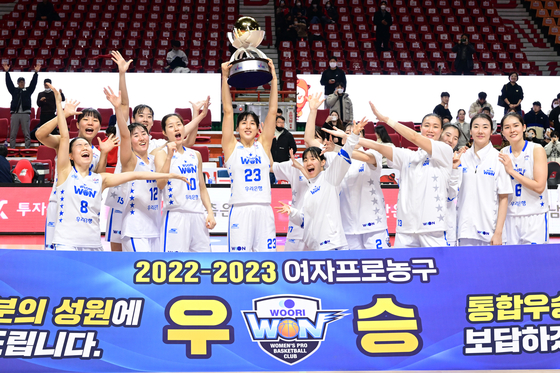 The Asan Woori Bank Woori Won celebrate after receiving the WKBL trophy at Sajik Gymnasium in Busan on Monday. [NEWS1]