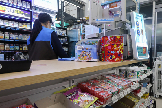 A cashier works at a convenience store in Seoul on Jan. 15. [YONHAP]